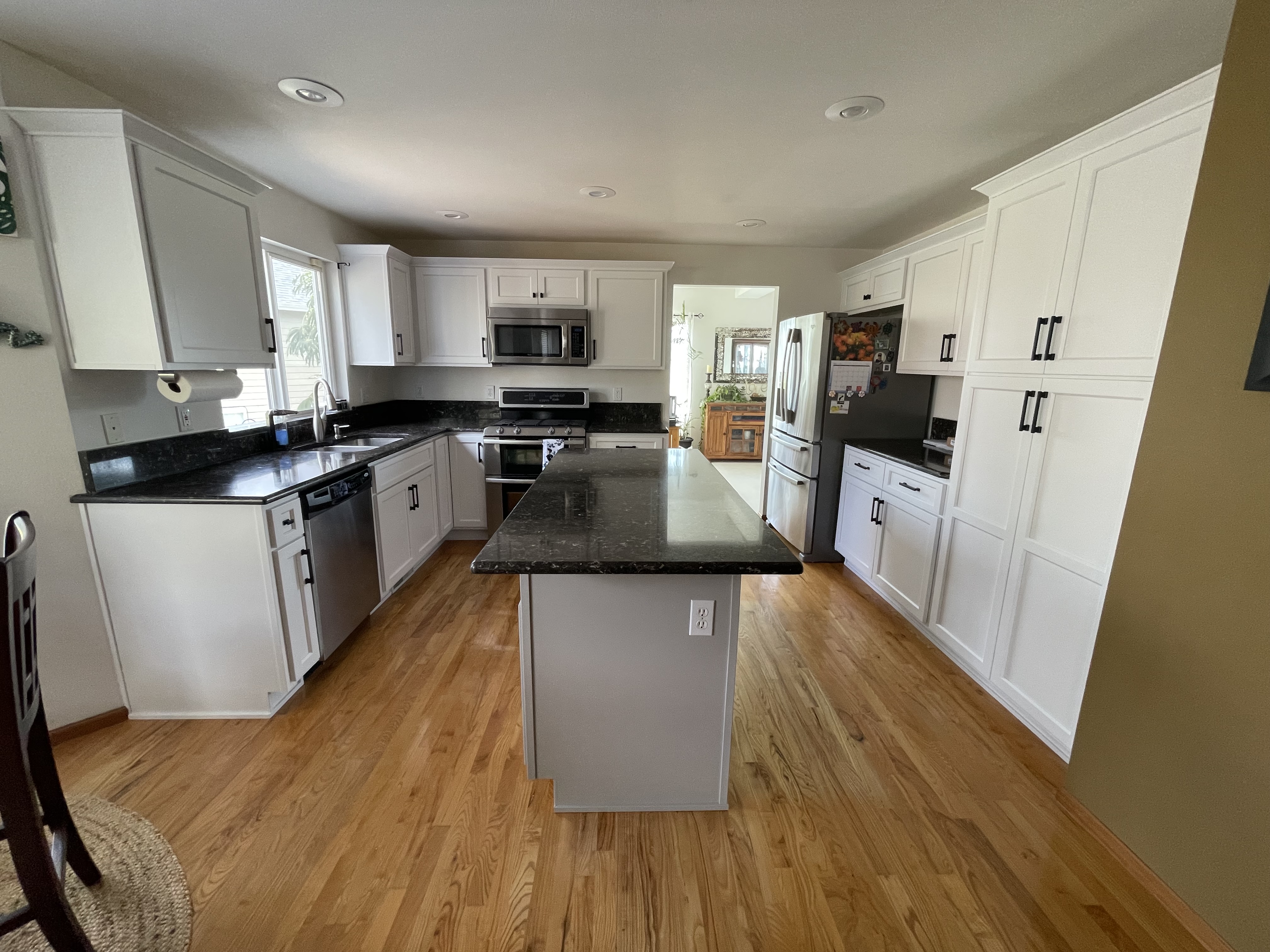 The same kitchen after refacing with white shaker cabinet doors and black hardware